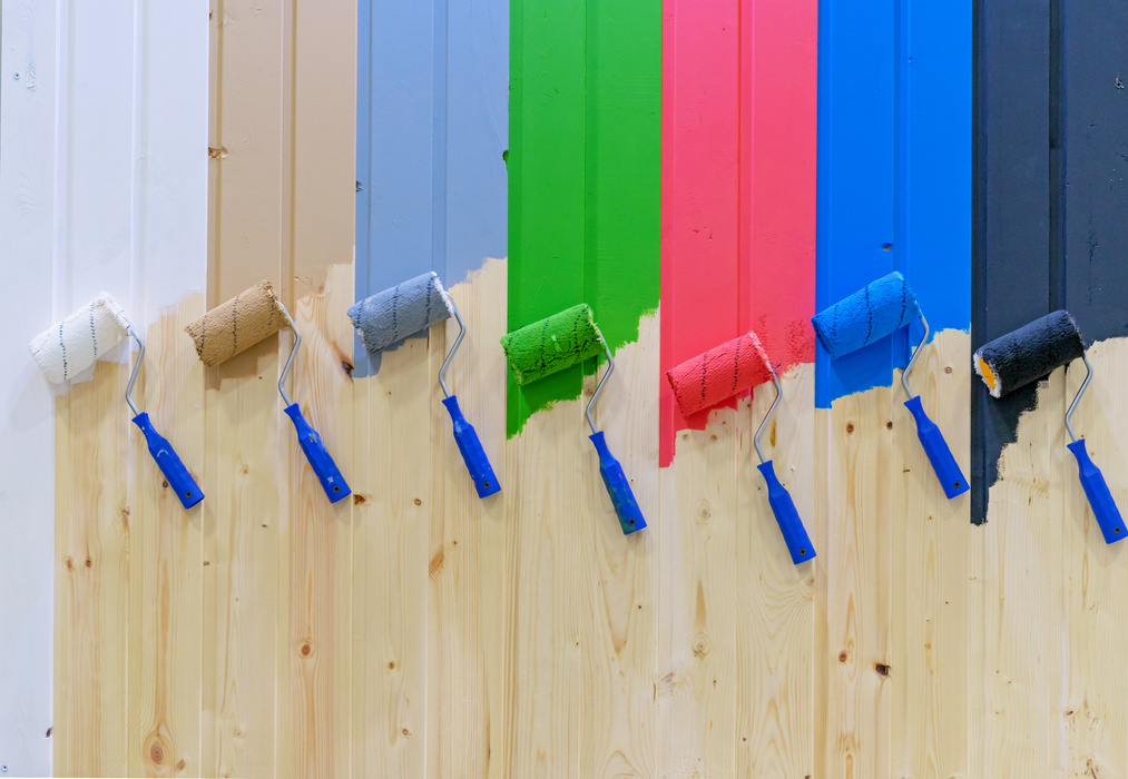 Paint rollers on a wooden wall. Multicolored paint rollers.